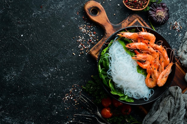 Macarrão de arroz com camarão e espinafre. Cozinha Tradicional Asiática. Vista do topo. Espaço livre para o seu texto.