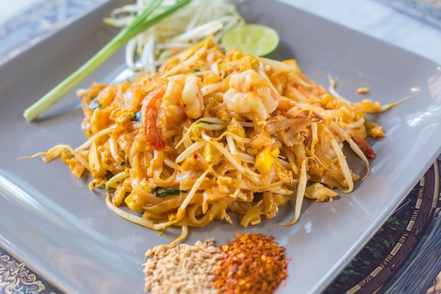 Macarrão de arroz frito com camarão Pad Thai é uma comida de rua tailandesa servida com broto de feijão