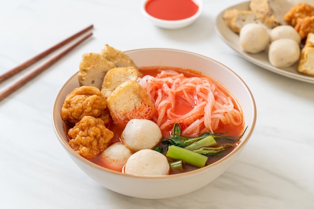Macarrão de arroz plano pequeno com bolinhos de peixe e bolinhos de camarão em sopa rosa Yen Ta Four ou Yen Ta Fo