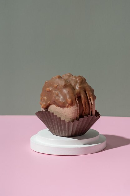 Macarrão de chocolate em um pódio em fundo rosa-verde pastel