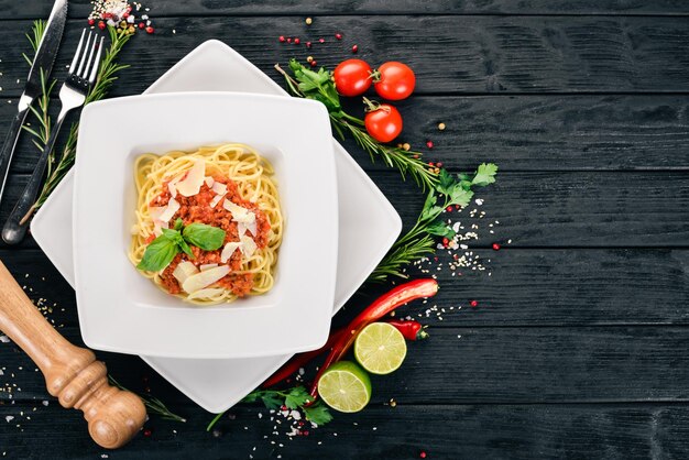 Macarrão de cozinha italiana com tomate e queijo parmesão Em um fundo de madeira Vista superior Copiar espaço