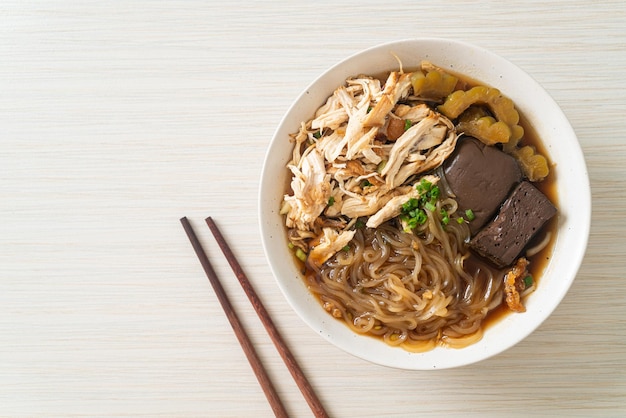 Macarrão de frango estufado em tigela de sopa marrom - comida asiática