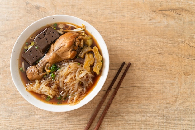 Macarrão de frango estufado em tigela de sopa marrom - estilo de comida asiática