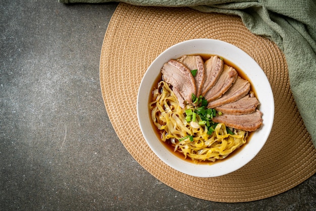 Macarrão de ovo com pato guisado em sopa marrom