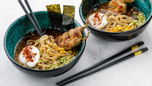 Macarrão de sopa de Ramen de cozinha japonesa com ovo de carne e legumes em uma mesa branca