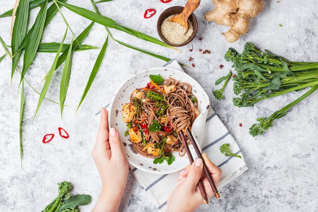 Macarrão de trigo sarraceno japonês Yakisoba com frango e vegetais em um fundo claro