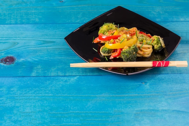 Macarrão de udon frito udon japonês com legumes em um prato preto