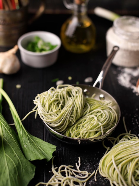 Macarrão de vegetais verde asiático cru caseiro no processo de cozimento caseiro na cozinha Mie Sawi Sayur