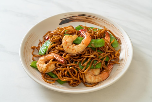 macarrão de yakisoba frito com ervilhas e camarões - estilo de comida asiática