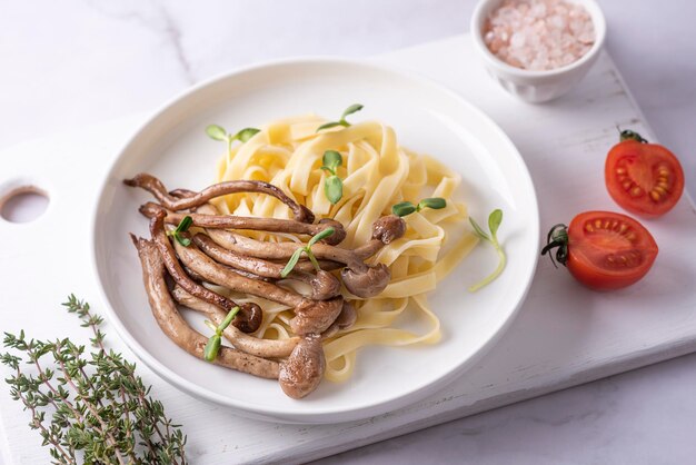 Macarrão e cogumelos fritos servidos no prato cozido shimeji com macarrão