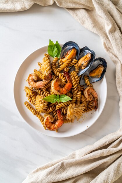 Macarrão em espiral frito com frutos do mar e molho de manjericão - estilo de comida de fusão