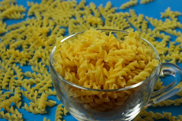 macarrão em uma caneca de vidro em um fundo azul