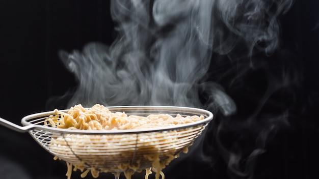 Macarrão em uma peneira que apenas cozido de panela quente