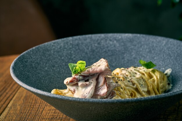 Macarrão espaguete à carbonara com molho branco e bacon em um prato. Cozinha italiana