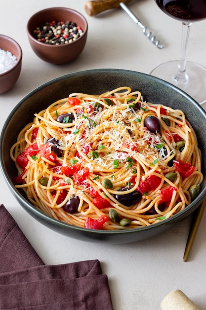 Macarrão espaguete Alla Puttanesca com alcaparras Kalamata azeitonas queijo tomate e anchovas Comida italiana