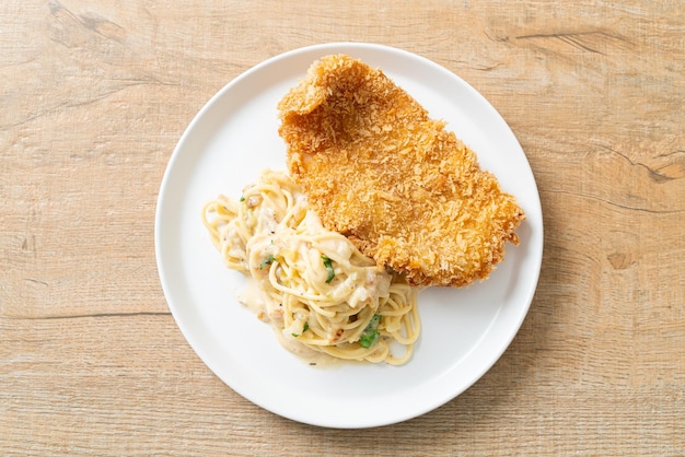 Macarrão espaguete ao molho de creme branco com peixe frito