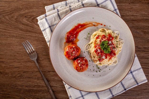 Macarrão espaguete com almôndegas e molho de tomate.