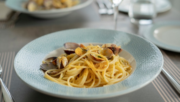 Foto macarrão espaguete com amêijoas e bottarga, comida mediterrânea