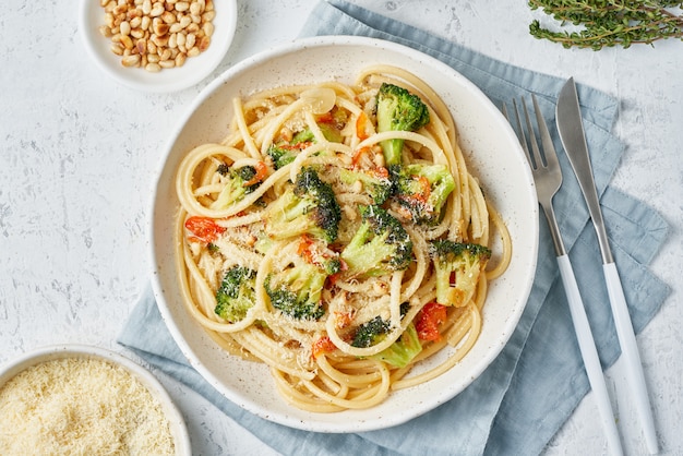 Macarrão espaguete com brócolis, bucatini com pimentão, alho, pinhões. Alimento para veganos, vegetarianos.