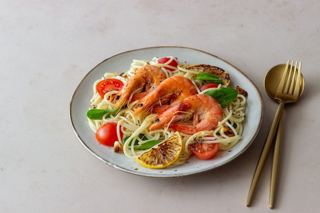 Macarrão espaguete com camarão, tomate, alho, espinafre e limão. Cozinha italiana. Frutos do mar. Dieta.