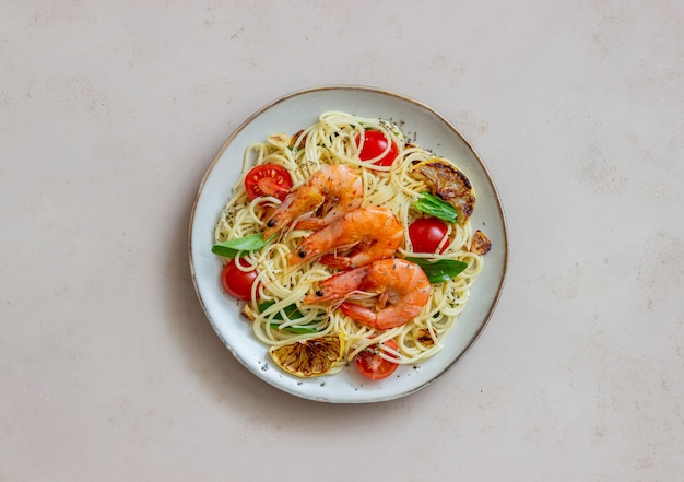 Macarrão espaguete com camarão, tomate, alho, espinafre e limão. Cozinha italiana. Frutos do mar. Dieta.
