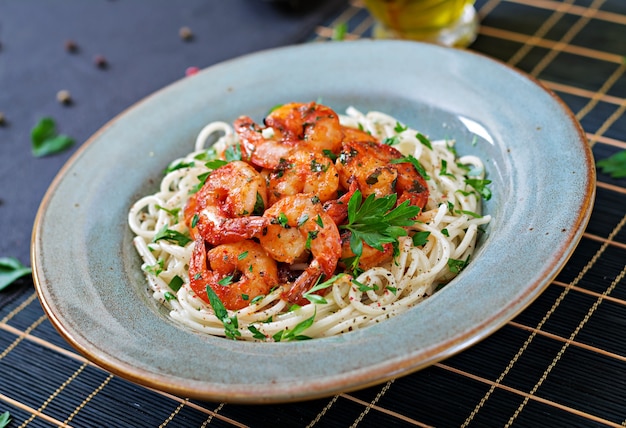 Macarrão espaguete com camarão, tomate e salsa picada. Comida saudável. Refeição italiana.