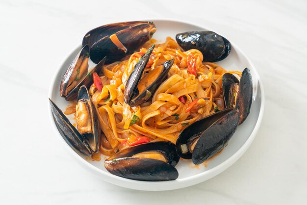 Macarrão espaguete com mexilhões ou amêijoas e molho de tomate - comida italiana