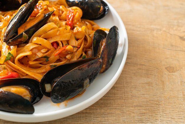 Macarrão espaguete com mexilhões ou amêijoas e molho de tomate - comida italiana