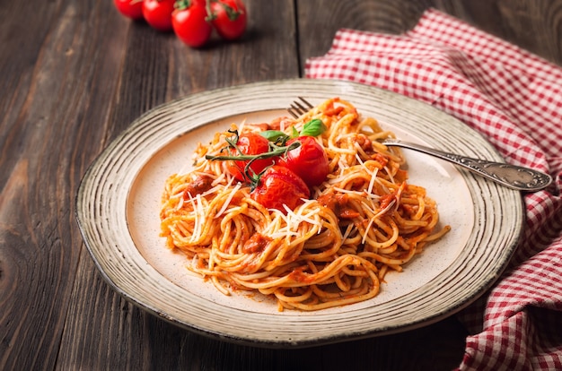 Macarrão espaguete com molho de tomate e cereja de tomate assado em madeira rústica