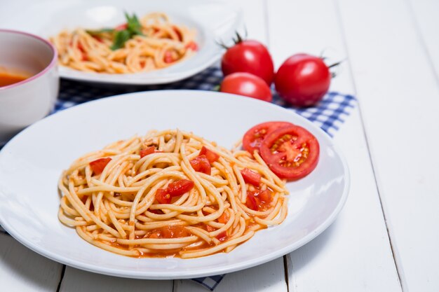 Macarrão espaguete com molho de tomate e sobre fundo de madeira