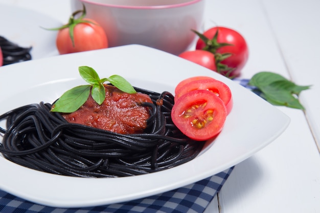 Macarrão espaguete com molho de tomate e sobre fundo de madeira