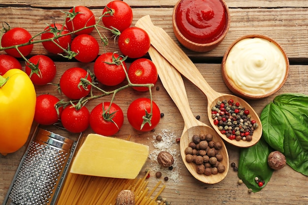 Macarrão espaguete com queijo tomate e manjericão em fundo de madeira rústica