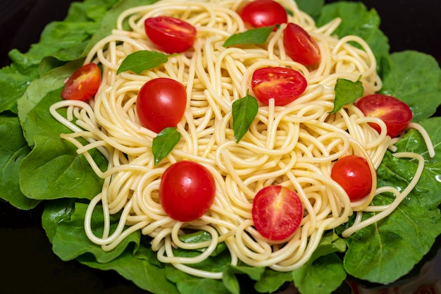 Macarrão espaguete com rúcula e tomate cereja