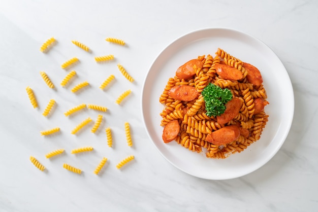 Macarrão espiral ou espirali com molho de tomate e salsicha. comida italiana