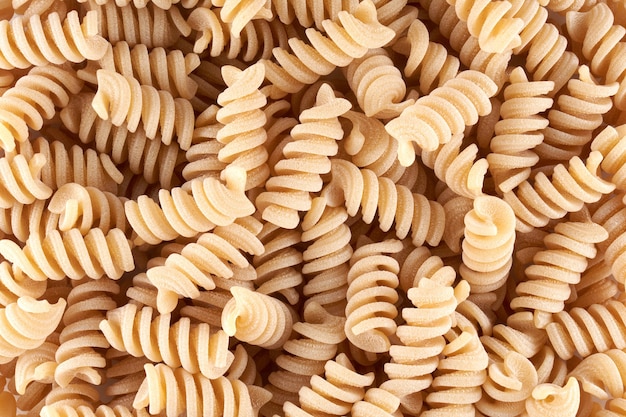 Macarrão espiral perto de fundo, massa e macarrão