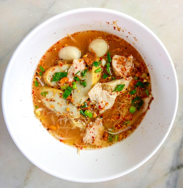 Macarrão estilo tailandês Tom Yum com carne de porco picada Sopa picante com pauzinhos de madeira