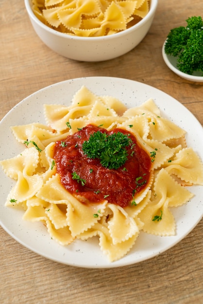 Macarrão farfalle ao molho de tomate com salsa - comida italiana