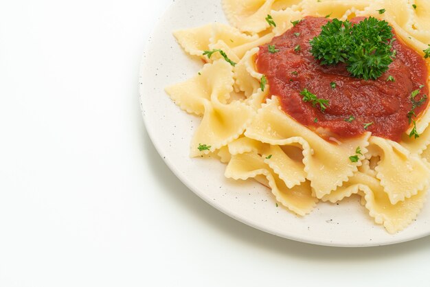 macarrão farfalle em molho de tomate com salsa isolado no fundo branco