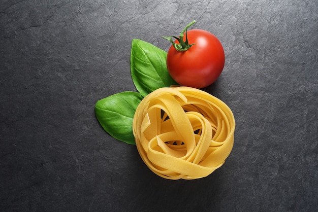 Macarrão fettuccine com folhas de manjericão e tomate