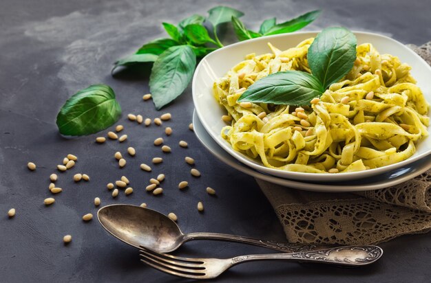 macarrão fettuccine com molho pesto de manjericão e pinhões em fundo de concreto cozinha italiana