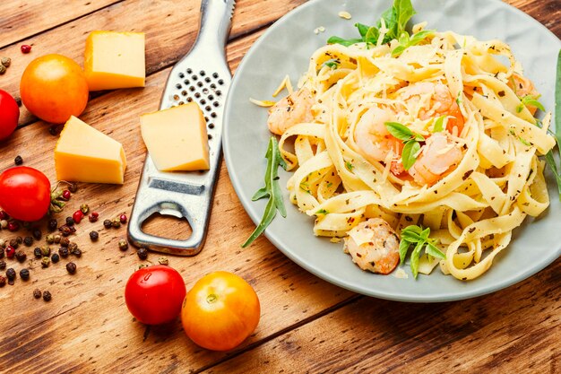 Macarrão Fettuccini com camarão na mesa de madeira. Comida italiana