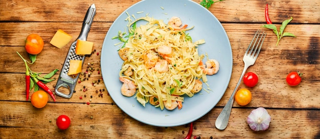 Macarrão Fettuccini com camarão na mesa de madeira. Comida italiana