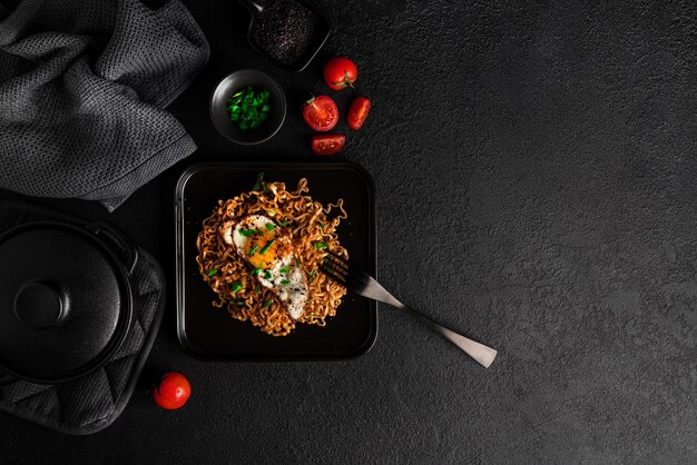 Macarrão fresco quente com fundo escuro de ovo frito. Foto de alta qualidade