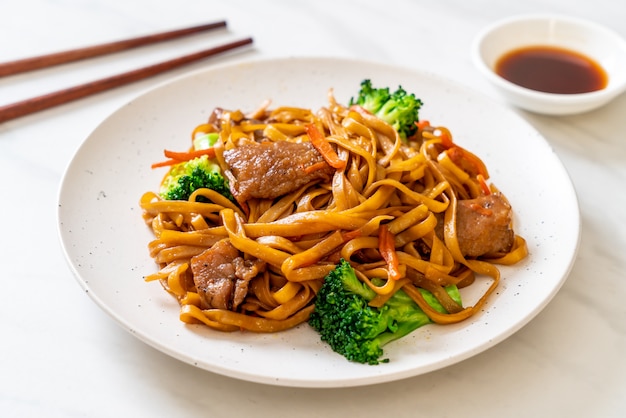 Foto macarrão frito com carne de porco e vegetais