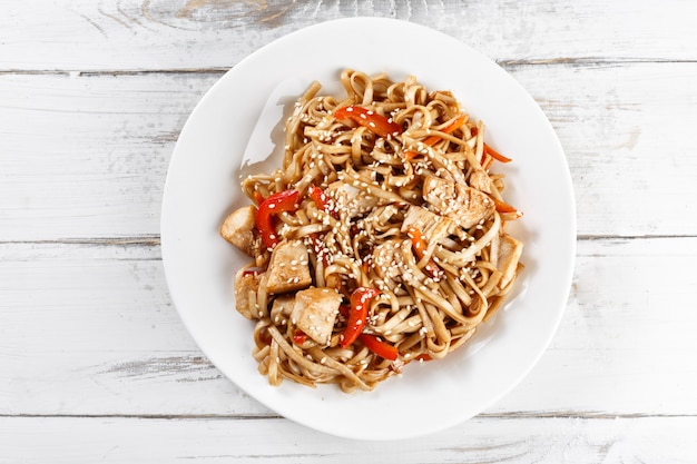 Macarrão frito udon com frango na mesa de madeira. Pad thai