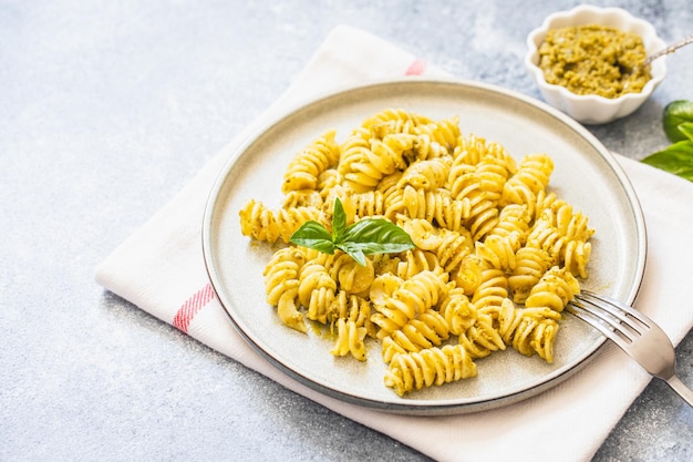 Macarrão Fusili com pesto de manjericão e ervas cozinha italiana fundo de pedra cinza Comida caseira