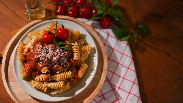 Macarrão Fusilli Comida italiana com molho de tomate caseiro servido com tomates frescos na mesa de jantar