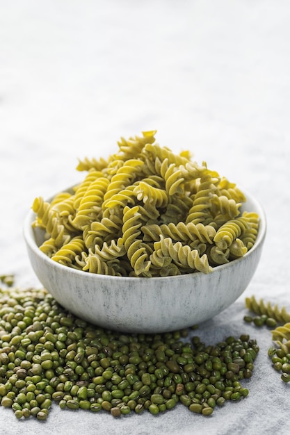 Macarrão fusilli de feijão mungo em um fundo têxtil cinza