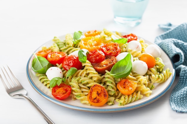 Macarrão fusilli saudável com molho pesto, tomate assado, mussarela