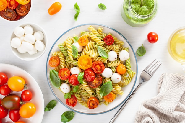 Macarrão fusilli saudável com molho pesto, tomate assado, mussarela